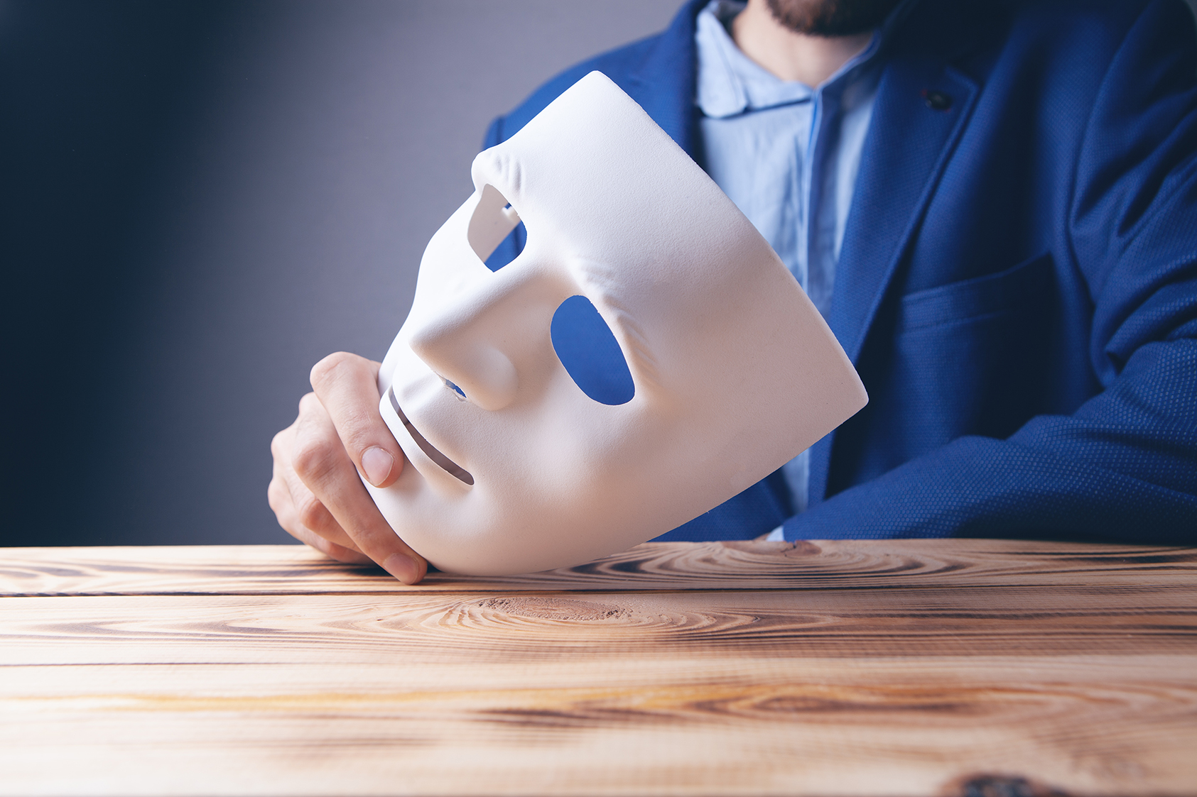 business person holding mask